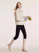 a lady in beige fur coat with black skinny jeans